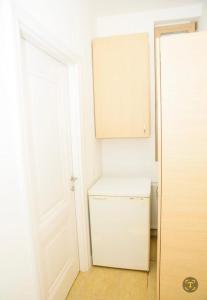 einen kleinen weißen Kühlschrank in einem Zimmer mit Tür in der Unterkunft Bistro Centru Vechi Craiova in Craiova