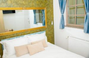 a bedroom with a white bed with a mirror at Bistro Centru Vechi Craiova in Craiova