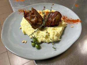 un plato de comida con carne y verduras. en Pensiunea Ioana en Rugineşti