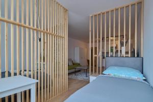 a bedroom with a large wooden partition with a bed at Central Apartments in Martin