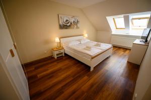 1 dormitorio con cama blanca y ventana en Apartmán U krále - 2 en Jičín