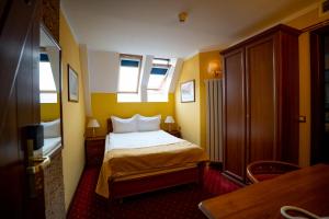 a small bedroom with a bed and two windows at House of Dracula Hotel in Poiana Brasov