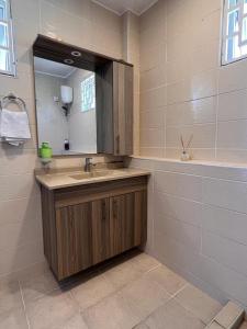 a bathroom with a sink and a mirror at SPACIOUS STUDIO IN NYALI with AC opposite voyager resort RITZ APARTMENT in Mombasa