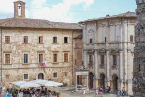 a large stone building with people standing in front of it at Palazzo Danesi in Montepulciano
