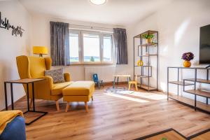 sala de estar con sillas amarillas y TV en HERZstück Erzgebirge, en Olbernhau