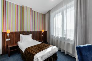 Postel nebo postele na pokoji v ubytování Rija VEF Hotel with FREE Parking