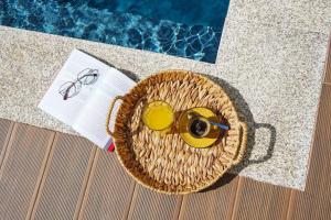 una cesta con una bebida y copas junto a una piscina en Magníficos Dias Atlânticos, en Moledo