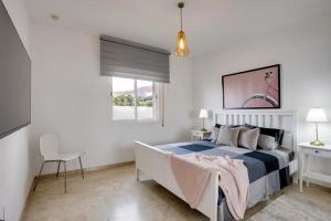 ein weißes Schlafzimmer mit einem Bett und einem Fenster in der Unterkunft Apartamento Mirador - Marina Bay in Estepona