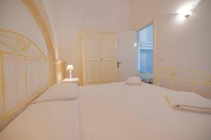 ウッジャーノ・ラ・キエーザにあるAgriturismo Le Tagliateの白いベッドルーム(ベッド1台、窓付)