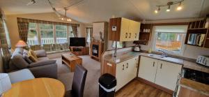 een keuken en een woonkamer met een bank en een tafel bij Bill's Retreat - Lodge & Hot tub in Morpeth