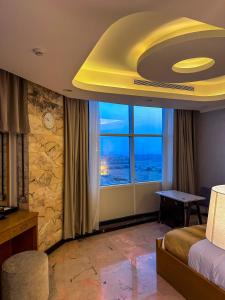 ジッダにあるBlue star hotelのベッドと大きな窓があるホテルの部屋
