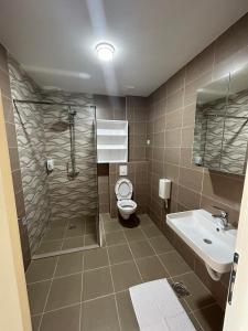 a bathroom with a shower and a toilet and a sink at Naš Dom Hotel in Bijelo Polje