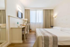 una camera d'albergo con letto e scrivania di Hotel Catalunya ad Alghero