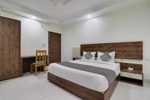 a bedroom with a bed and a desk and a chair at Townhouse Hotel Rooftop in Rishīkesh