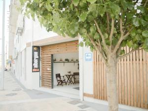 a tree in front of a building with a table at ALBERGUE ALOXA HOSTEL in Pontevedra