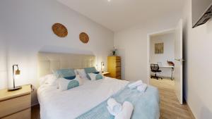 Un dormitorio con una gran cama blanca con almohadas azules. en Viana Vivienda Turística moderna y reformada con WiFi, en Bilbao