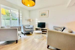 Una sala de estar con dos sofás y un televisor. en Ti-hañv - la maison d'été, en Crozon