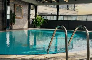 uma piscina com dois carris de metal ao lado de um edifício em Hotel Zurich Istanbul Old City em Istambul