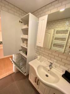 ein weißes Badezimmer mit einem Waschbecken und einem Spiegel in der Unterkunft Трехкомнатная квартира у моря in Antalya
