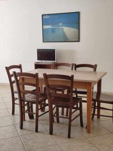 een houten tafel en stoelen met een laptop op een bureau bij Portu Hill Apartments in Àrbatax +129 foto's