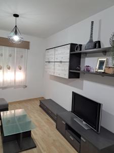 a living room with a tv and a table at Centrico, Parking incluido in Jaén