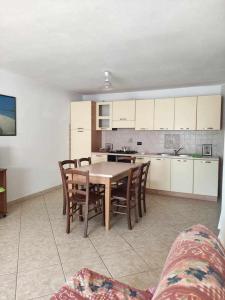 een keuken met een tafel en stoelen in een kamer bij Portu Hill Apartments in Àrbatax