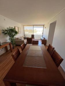 a living room with a large wooden table and chairs at Exclusivo y cómodo departamento in Copiapó