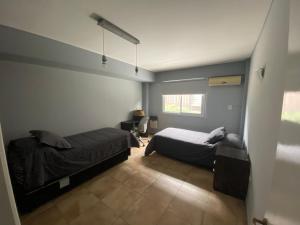 a bedroom with two beds and a window at Oasis 1.6 in Mendoza