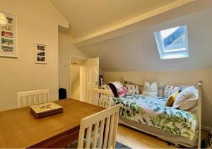 a bedroom with a bed and a table and a window at Luxury 4 Bedroom Seaside Apartment - Glan Y Werydd House in Barmouth