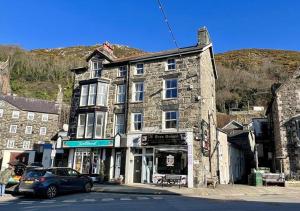 a car parked in front of a stone building at Luxury 4 Bedroom Seaside Apartment - Glan Y Werydd House in Barmouth
