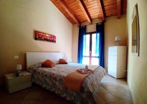 een slaapkamer met een bed in een kamer met een raam bij Grazioso attico vicino alla spiaggia e al centro in Castelsardo