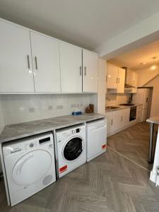 a kitchen with a washer and dryer in it at Smart ROOMS Easy access to Central London By Piccadilly Line in New Southgate