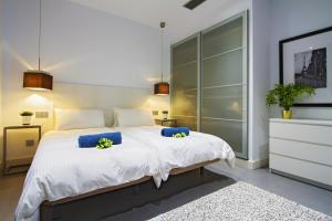 a bedroom with a large white bed with blue pillows at Luxury Los Mojones Villa Short Walk To Old Town Private Heated Pool Villa Los Mojones Angie Puerto Del Carmen in Tías +20 photos