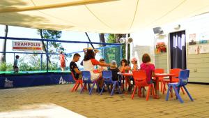 Easyatent Safari tent Zelena Laguna في بوريتش: مجموعة اطفال جالسين على طاولة في فصل