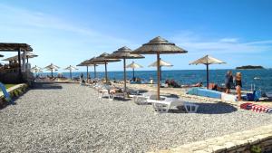 einen Strand mit Stühlen und Sonnenschirmen und Menschen darauf in der Unterkunft Easyatent Safari tent Zelena Laguna in Poreč