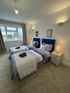 Smart ROOMS Easy access to Central London By Piccadilly Line في New Southgate: غرفة نوم بسريرين ومصباح ونافذة