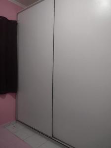 two sliding doors in a room with pink walls at Casa perto da praia mobiliada in Itanhaém
