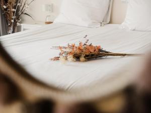 a bundle of dried flowers on a bed at Op Oost Boutique hotel & Restaurant het Kook Atelier in Oosterend