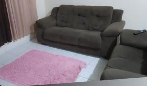 a living room with a couch and a pink rug at Casa perto da praia mobiliada in Itanhaém