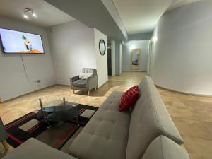 sala de estar con sofá y TV de pantalla plana en Oasis 1.6 en Mendoza