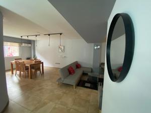 un soggiorno con tavolo, divano e specchio di Oasis 1.6 a Mendoza