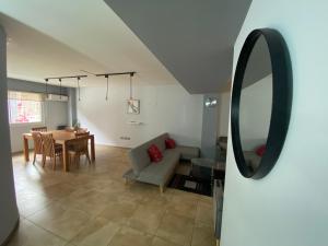 a living room with a table and a couch and a mirror at Oasis 1.6 in Mendoza