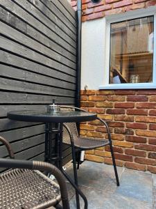 a table and chairs on a patio with a brick wall at Urban Delight Escape in Great Yarmouth