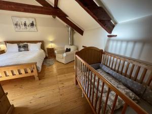 um quarto com uma cama e uma escada num quarto em The Granary Stunning Barn Conversion em Broadwoodkelly