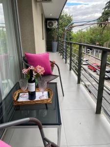 a balcony with a purple pillow and a vase of flowers at In Calma Mdz in Mendoza