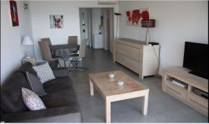 ein Wohnzimmer mit einem Sofa und einem Couchtisch in der Unterkunft Le Chantilly in Cagnes-sur-Mer