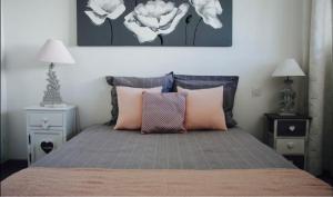 ein Schlafzimmer mit einem Bett mit rosa Kissen und zwei Nachttischen in der Unterkunft Le Chantilly in Cagnes-sur-Mer