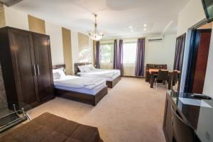 a hotel room with two beds and a television at Villa Milano in Kovin