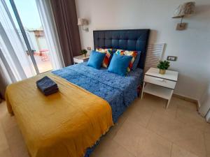 um quarto com uma cama grande com lençóis azuis e almofadas azuis em By Paseo de Colón Apartment em Barcelona