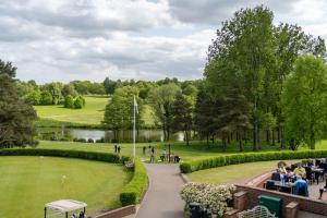 um grupo de pessoas sentadas em mesas em um parque em Stoke By Nayland Hotel, Golf & Spa em Leavenheath